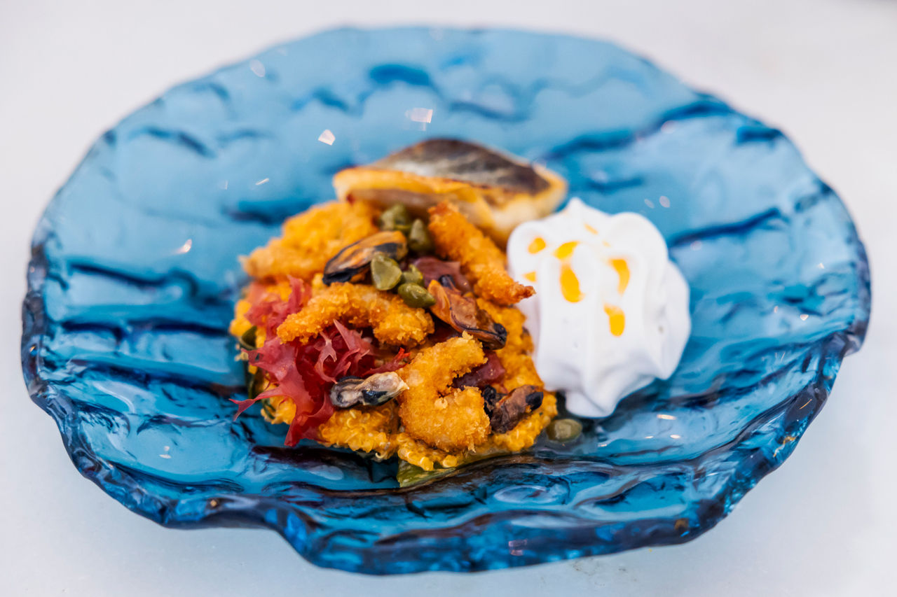 O quinoto de robalo, tempura de gamba, mexilhão, alga kombu e espuma de ostra é inspirado num risoto, mas, ao invés de arroz, é cozinhado com quinoa