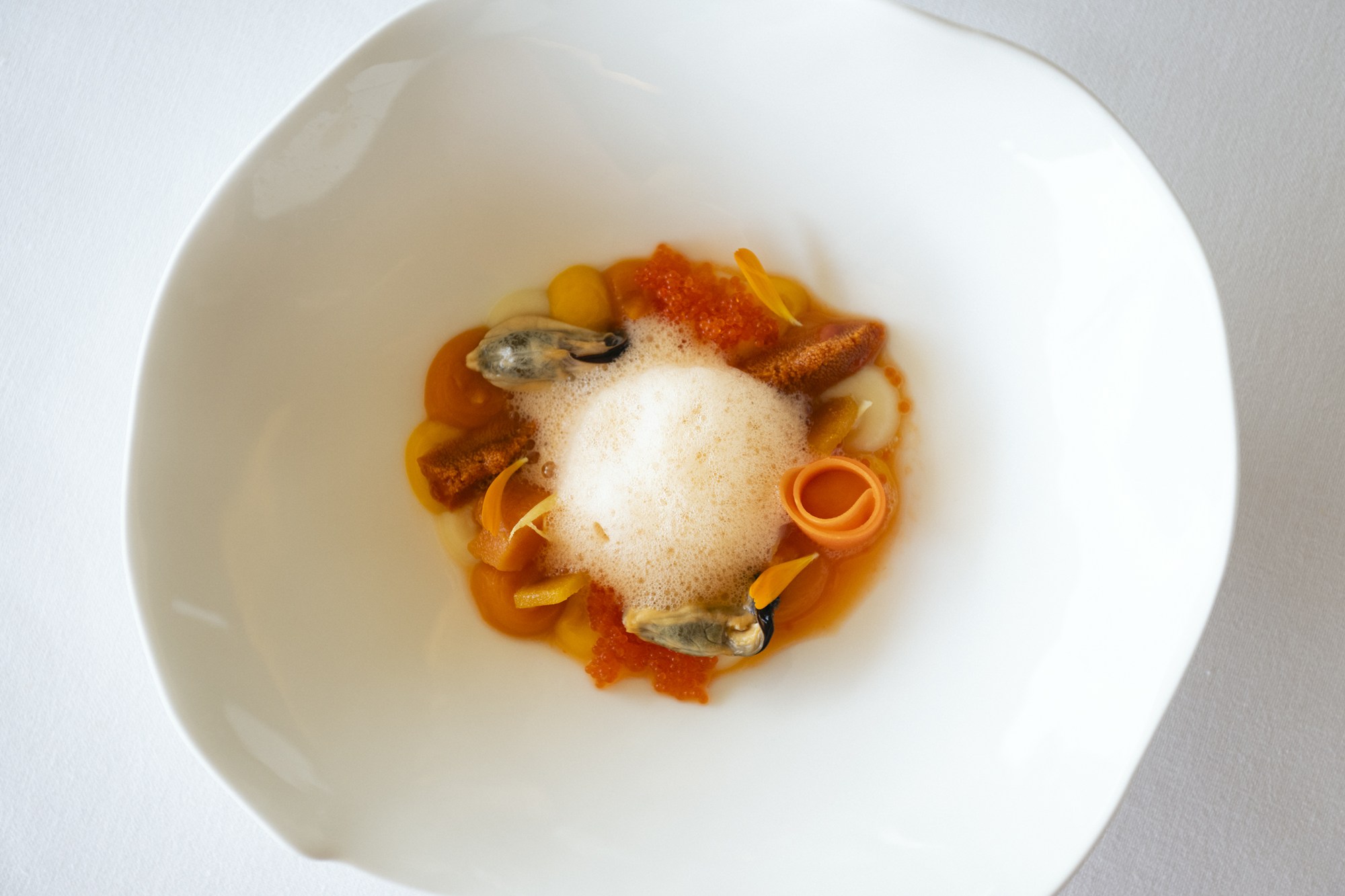 La ensalada de naranja va con pures de zanahoria y boniato, mejillones, erizo de mar y huevas de pez volador.