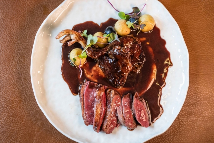 Pichón Bresse braseado a base de mantequilla con una salsa que lleva un toque de chocolate ecuatoriano.