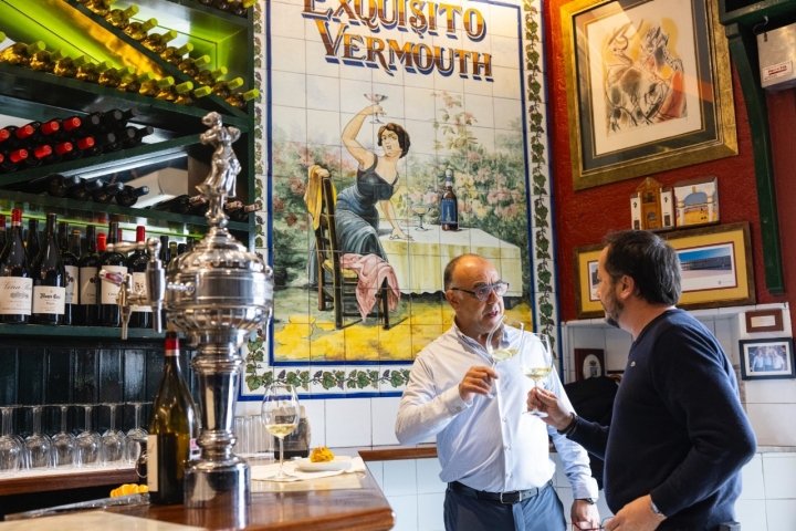 Dos hombres toman un vino en el restaurante.