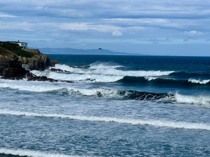 Surfista cogiendo olas en la playa de Tapia de Casariego